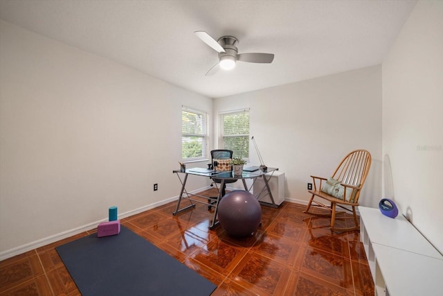 interior space with a ceiling fan and baseboards