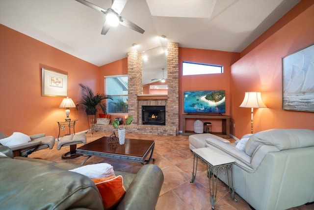 tiled living area with vaulted ceiling, a brick fireplace, a healthy amount of sunlight, and ceiling fan