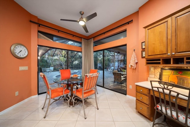 dining area with light tile patterned floors, a ceiling fan, and baseboards