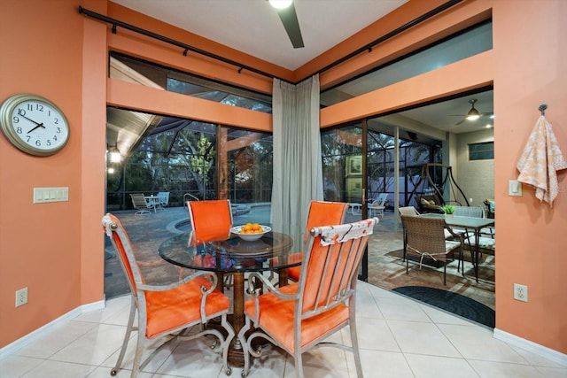 dining room with tile patterned flooring, a sunroom, and ceiling fan