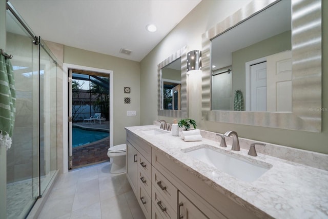 full bathroom featuring double vanity, a stall shower, toilet, and a sink