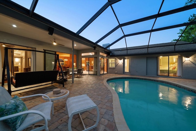 outdoor pool with glass enclosure, a patio area, and outdoor lounge area