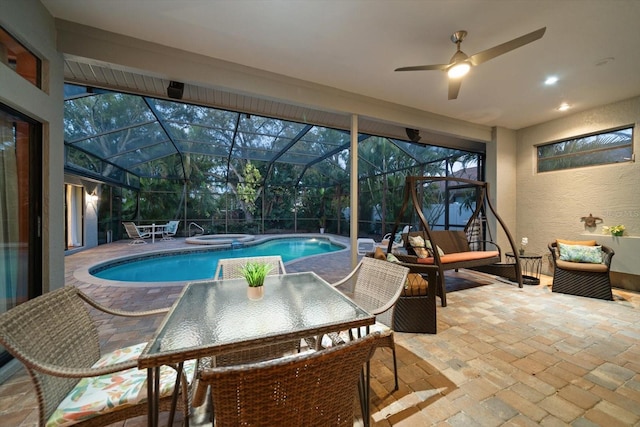 pool featuring glass enclosure, an in ground hot tub, a ceiling fan, and a patio area