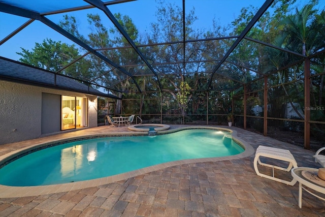 outdoor pool with an in ground hot tub, a lanai, and a patio area