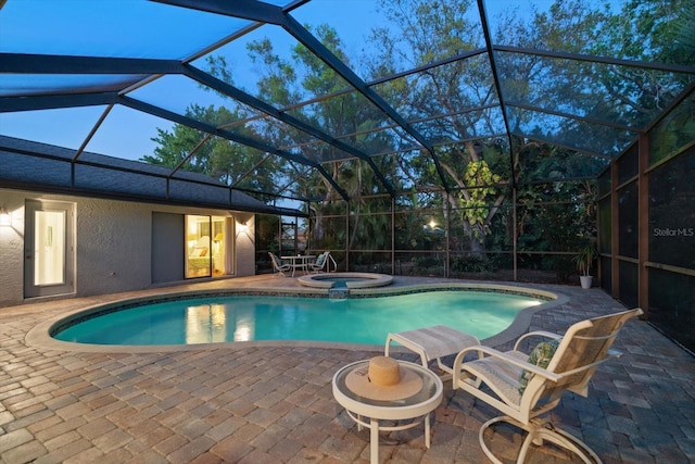 view of pool featuring a lanai, a patio area, and a pool with connected hot tub