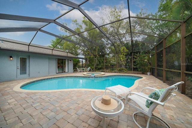 view of pool featuring a lanai, a pool with connected hot tub, and a patio