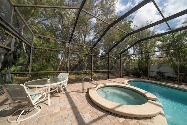 view of pool with glass enclosure, a patio area, and a pool with connected hot tub