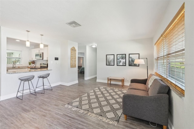 sitting room featuring visible vents, baseboards, and wood finished floors