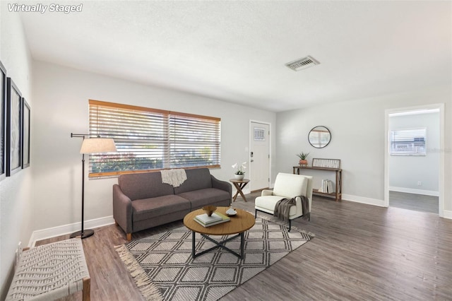 living room with visible vents, wood finished floors, and baseboards