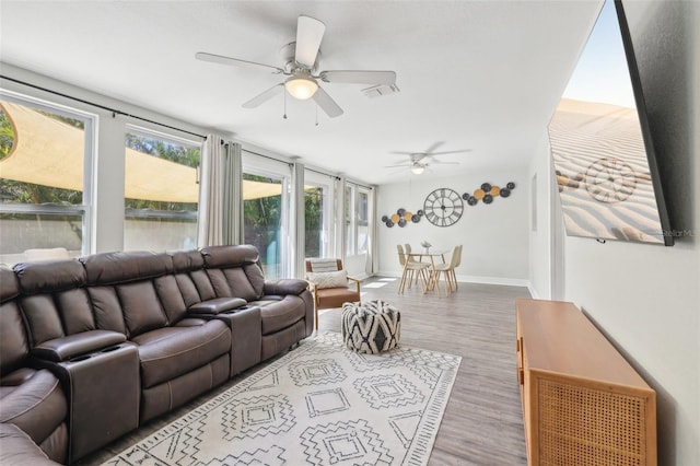 living room with visible vents, baseboards, wood finished floors, and a ceiling fan