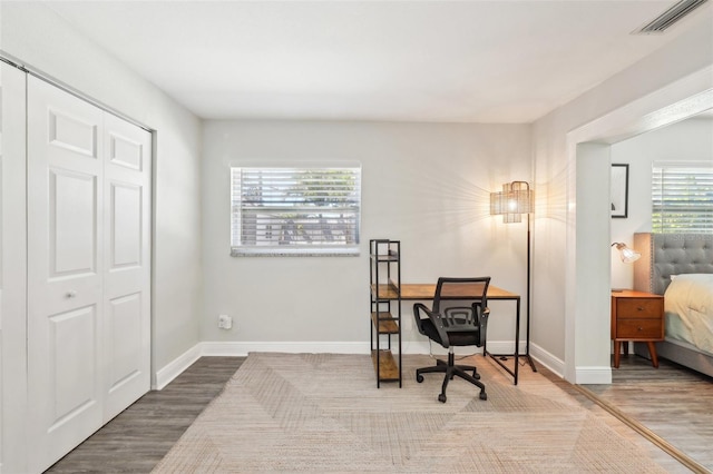 home office featuring visible vents, baseboards, and wood finished floors