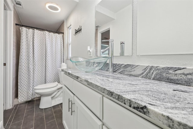 bathroom featuring vanity, visible vents, curtained shower, tile patterned floors, and toilet