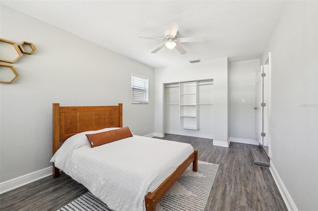 bedroom featuring dark wood-style floors, visible vents, ceiling fan, and baseboards