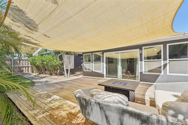 wooden deck with an outdoor living space with a fire pit and fence