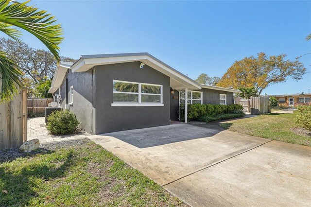 view of front of property with a front yard, fence, driveway, and stucco siding