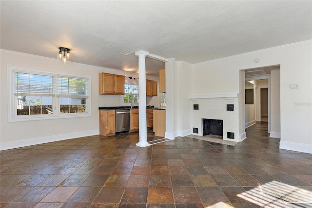 unfurnished living room with visible vents, stone tile flooring, a fireplace, crown molding, and baseboards