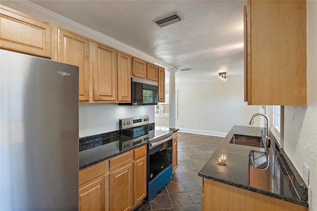 kitchen with dark stone countertops, baseboards, visible vents, a sink, and stainless steel appliances