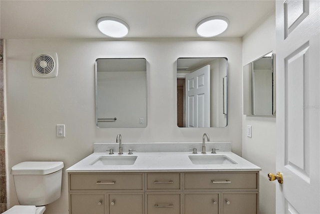 full bath with double vanity, visible vents, toilet, and a sink