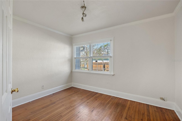 spare room with baseboards, wood-type flooring, and ornamental molding