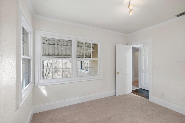 unfurnished room featuring visible vents, baseboards, carpet, and ornamental molding