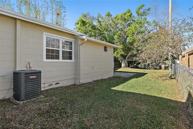 view of yard with central air condition unit and a fenced backyard