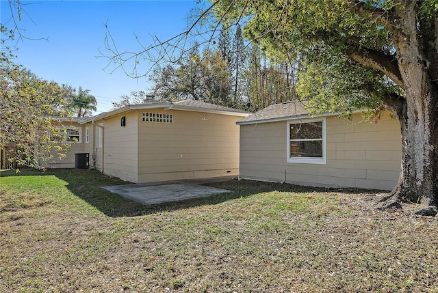 rear view of house with a patio area, central AC unit, and a lawn