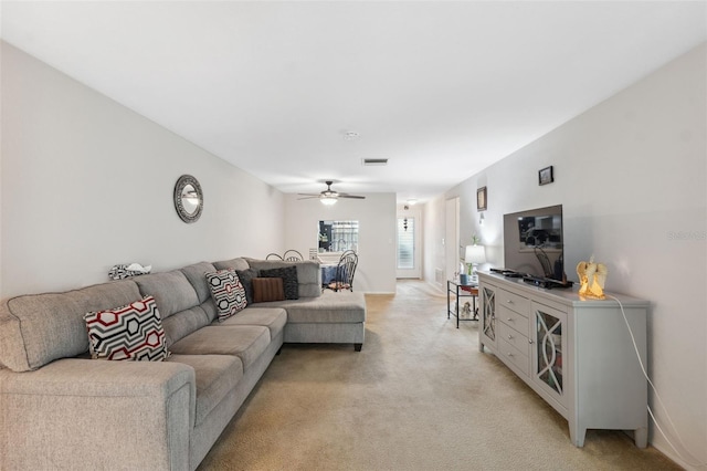 living area featuring a ceiling fan, light colored carpet, and visible vents