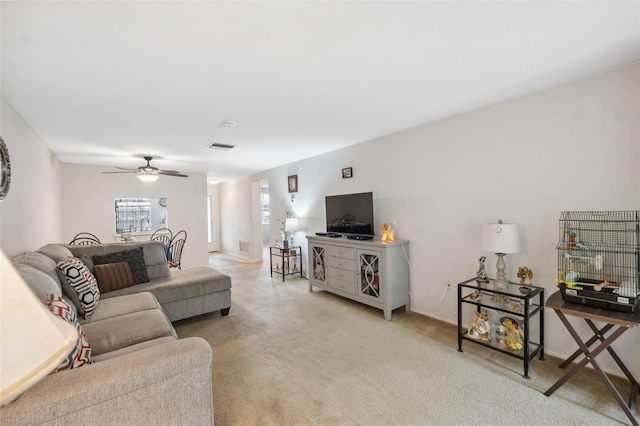 living area featuring a ceiling fan, light colored carpet, and visible vents