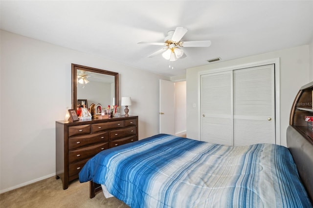 bedroom featuring baseboards, visible vents, ceiling fan, a closet, and light colored carpet