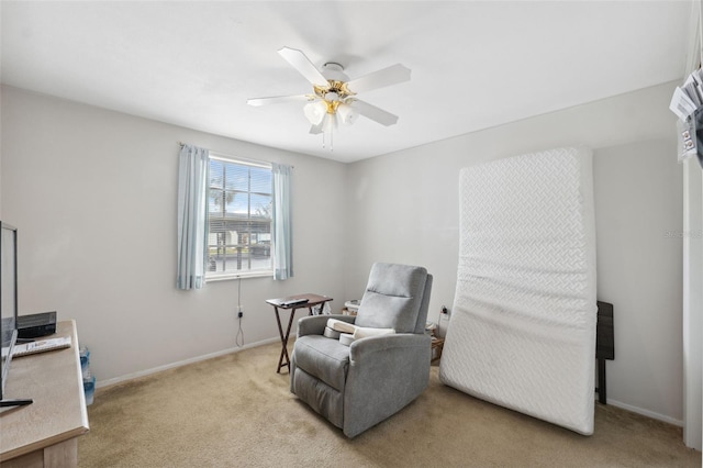 sitting room with baseboards, light colored carpet, and ceiling fan