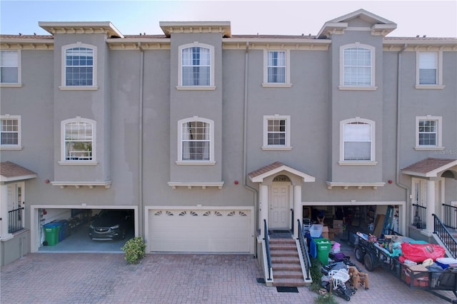 townhome / multi-family property featuring stucco siding, a garage, and driveway