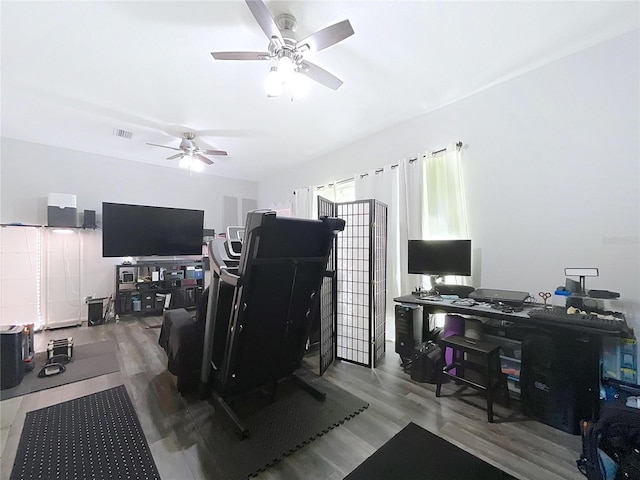 home office with wood finished floors, visible vents, and ceiling fan