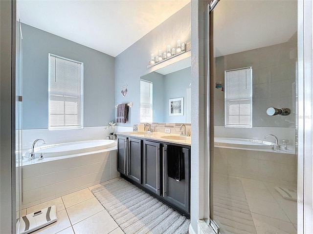 bathroom with a sink, a bath, and tile patterned floors