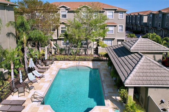 pool featuring a patio area, a residential view, and fence