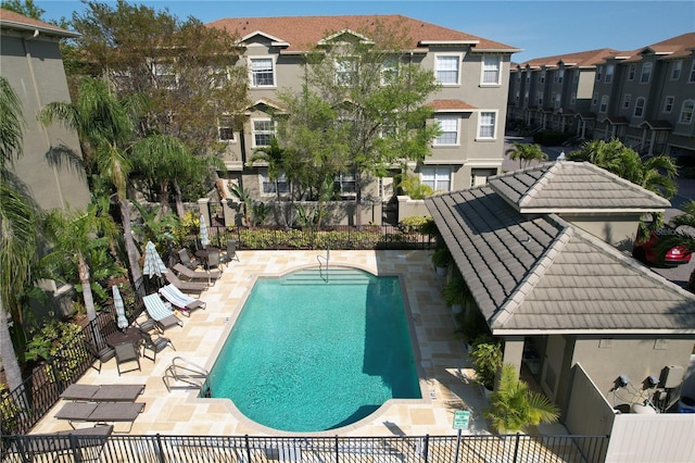 pool featuring a residential view, a patio, and fence