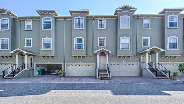 townhome / multi-family property featuring a garage, driveway, and stucco siding