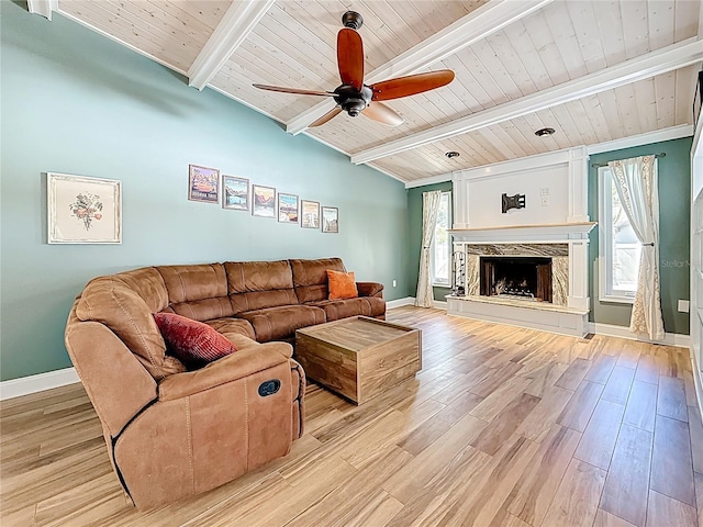 living room featuring baseboards, a premium fireplace, ceiling fan, light wood-style floors, and wooden ceiling