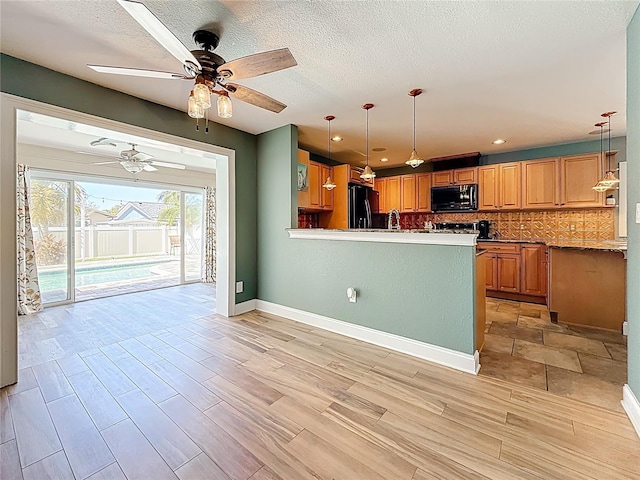 kitchen with black appliances, light wood-style floors, tasteful backsplash, and ceiling fan