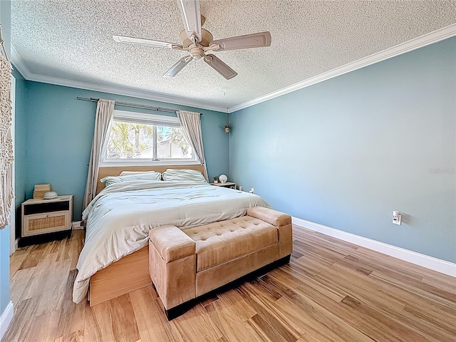 bedroom featuring light wood-style flooring, a textured ceiling, baseboards, and ornamental molding