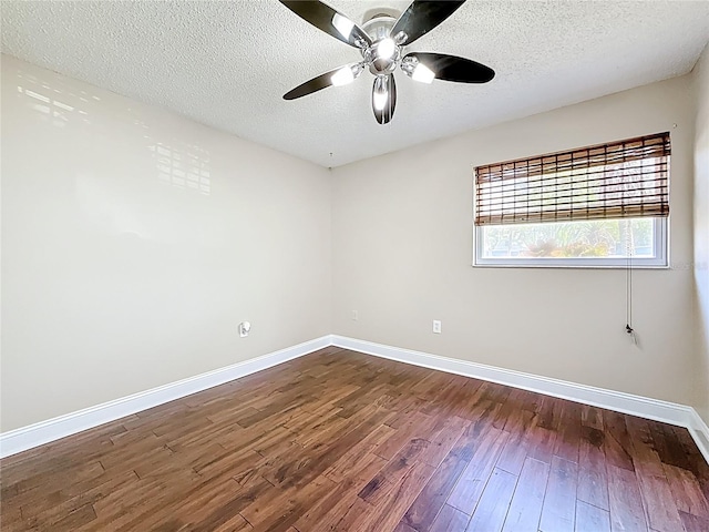 unfurnished room featuring dark wood-type flooring, a ceiling fan, baseboards, and a textured ceiling