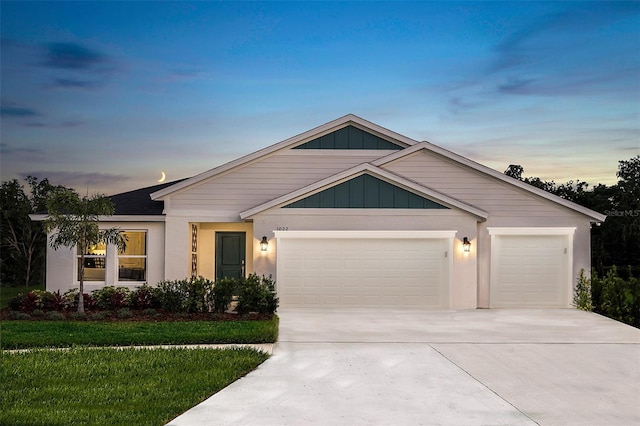 view of front facade featuring a yard, stucco siding, concrete driveway, and a garage