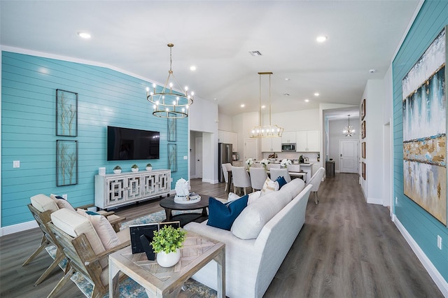 living area with dark wood-style floors, a notable chandelier, an accent wall, and baseboards