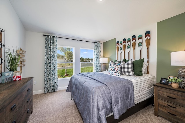 bedroom featuring light carpet and baseboards