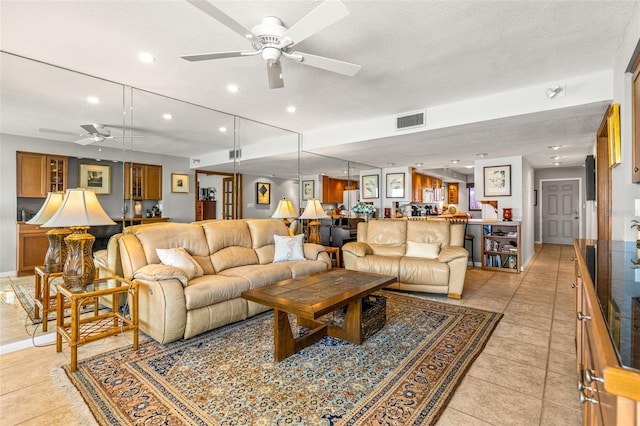 living area with visible vents, a ceiling fan, a textured ceiling, recessed lighting, and light tile patterned flooring