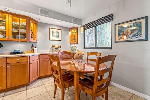 dining room featuring light tile patterned floors, visible vents, and baseboards