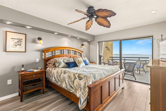 bedroom featuring ceiling fan, baseboards, light wood-style floors, and access to exterior