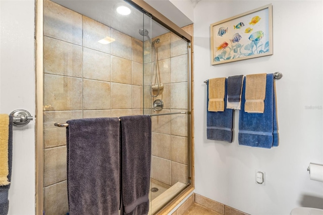 full bathroom featuring baseboards and a shower stall