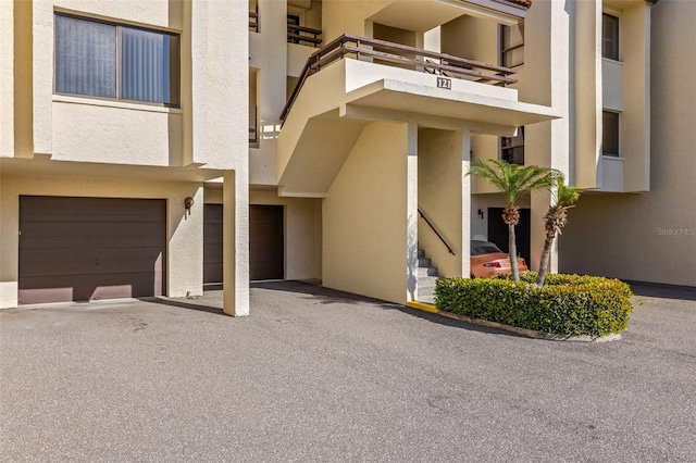 doorway to property with an attached garage and stucco siding