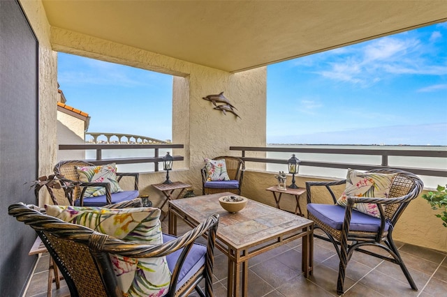 balcony featuring a water view and outdoor lounge area