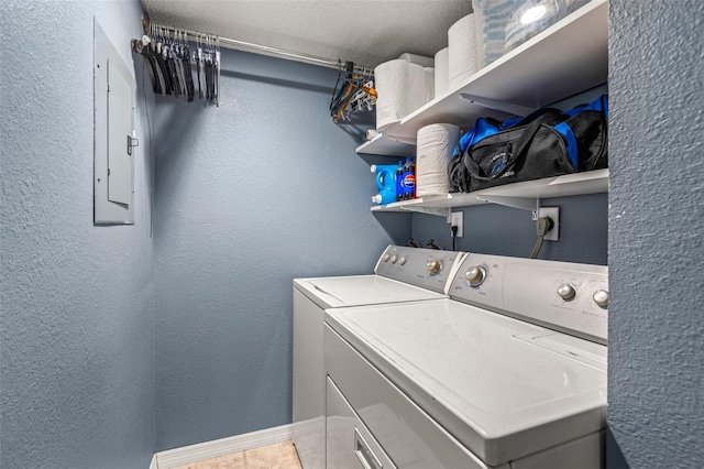 laundry room featuring laundry area, electric panel, separate washer and dryer, and a textured wall